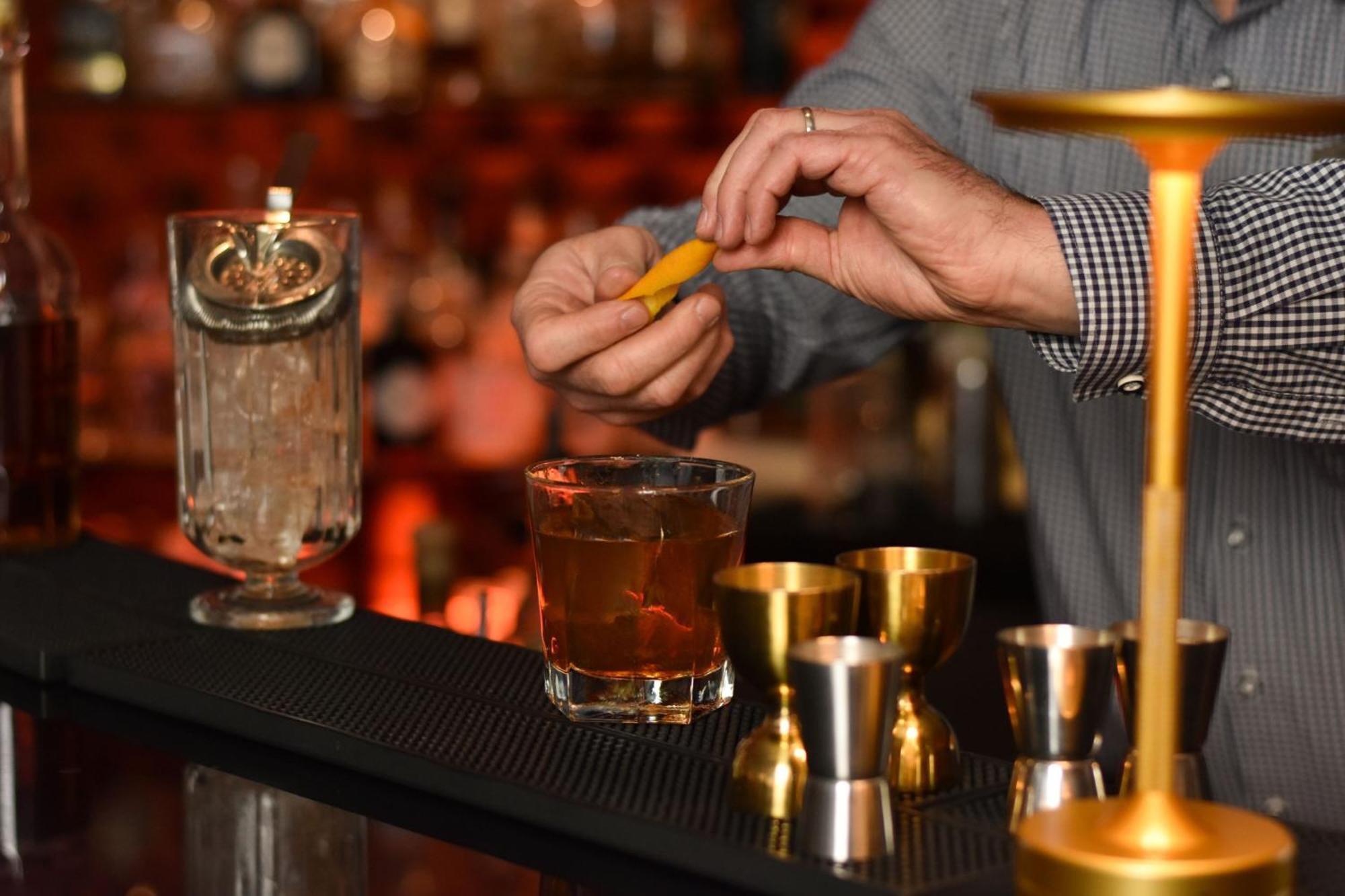 فندق كولونيا ماريوت المظهر الخارجي الصورة A bartender adding a lemon twist to a cocktail