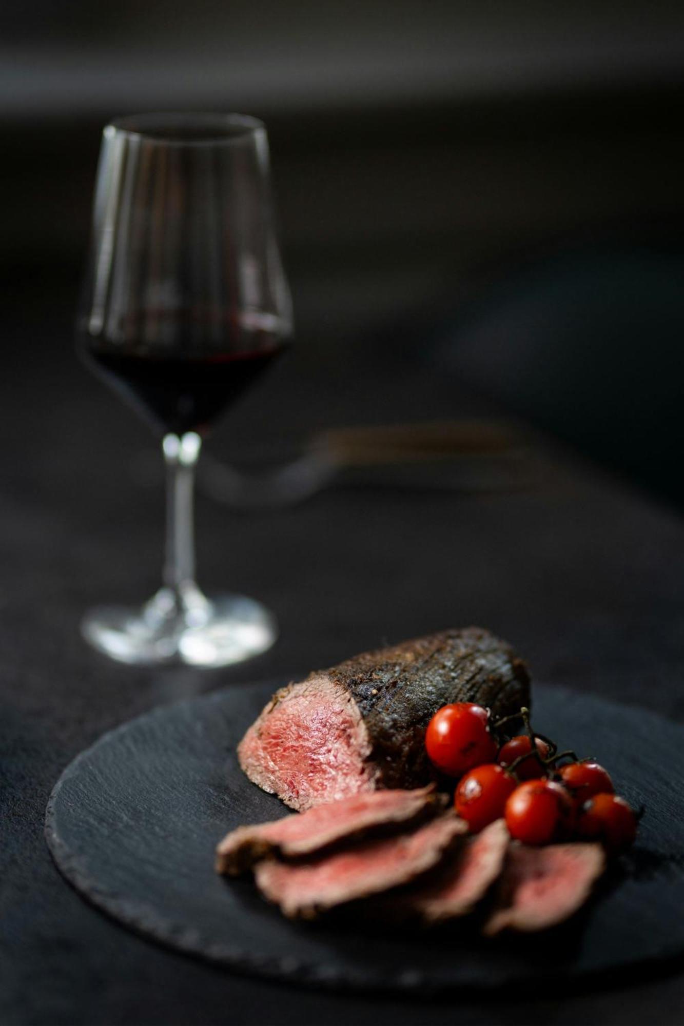 فندق كولونيا ماريوت المظهر الخارجي الصورة A glass of red wine and a steak